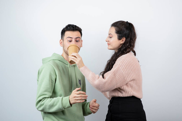 Brunette woman giving to try drink to young man model . High quality photo - Fotoğraf, Görsel
