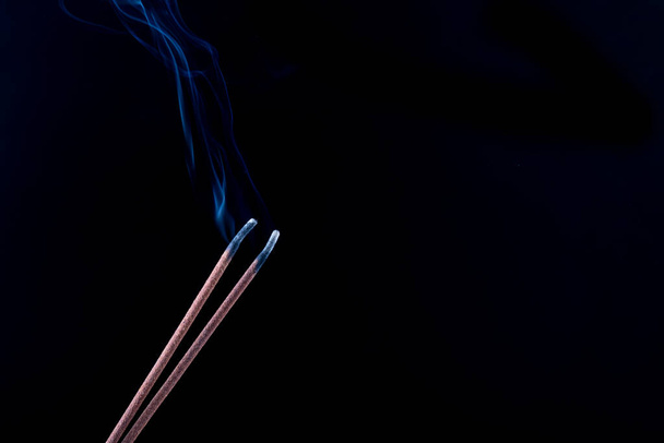 black background, two incense sticks. there is smoke, smell, incense close-up - Photo, Image