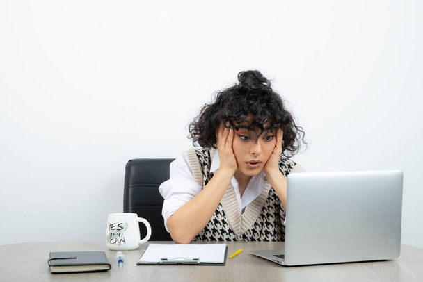Foto de una trabajadora de oficina sentada en el escritorio con portapapeles. Foto de alta calidad - Foto, Imagen