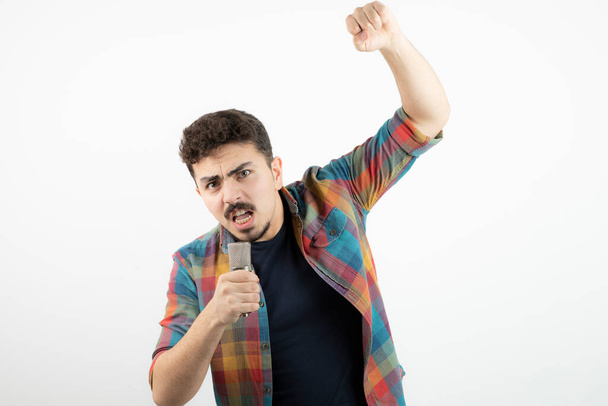 Picture of young handsome man speaking in microphone . High quality photo - Φωτογραφία, εικόνα