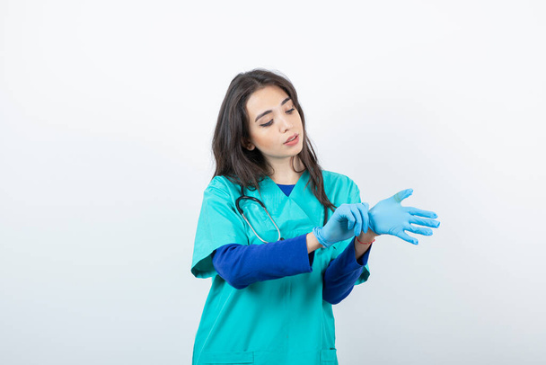 Portrait d'une jeune infirmière avec stéthoscope portant des gants médicaux. Photo de haute qualité - Photo, image
