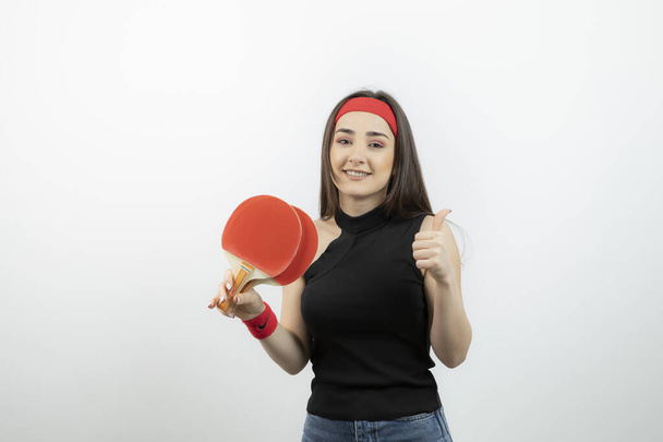 Žena stolní tenista drží pár raket pro servírování míče. Kvalitní fotografie - Fotografie, Obrázek