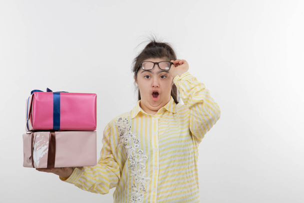 девушка с синдромом Дауна позирует с подарочными коробками - Фото, изображение
