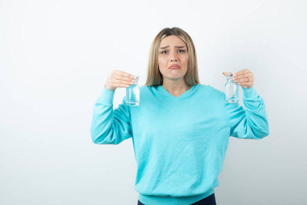 Photo of charming woman holding two glass pitchers of water . High quality photo - Foto, Bild