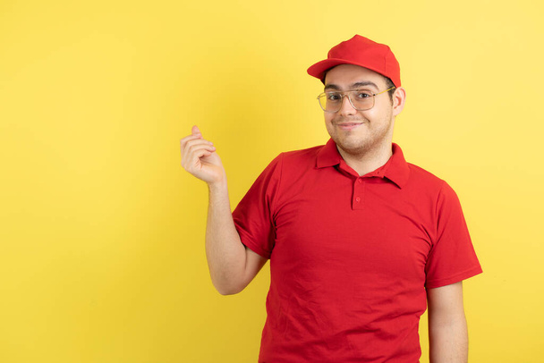 Kuva miespuolisesta kuriirista punaisessa univormussaan keltaisen päällä. Laadukas kuva - Valokuva, kuva