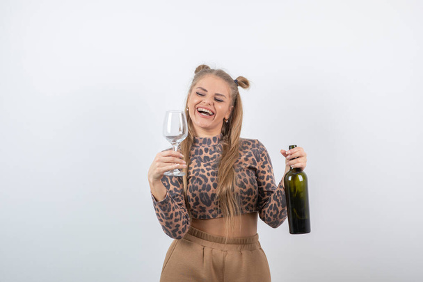 Foto de la joven modelo atractiva mujer sosteniendo botella de vino y vidrio. Foto de alta calidad - Foto, Imagen