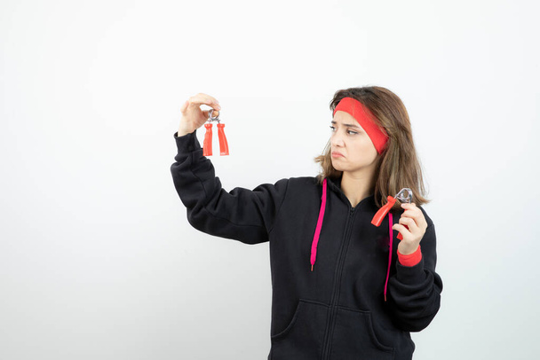 Фотографія молодої спортивної дівчини, що тримає рожеву пляшку води. Високоякісна фотографія
 - Фото, зображення