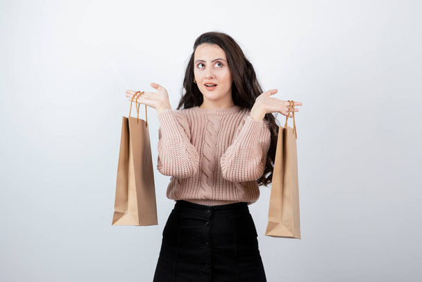 Портрет красивая женщина в свитере держит пакеты с покупками после покупки. Высокое качество фото - Фото, изображение