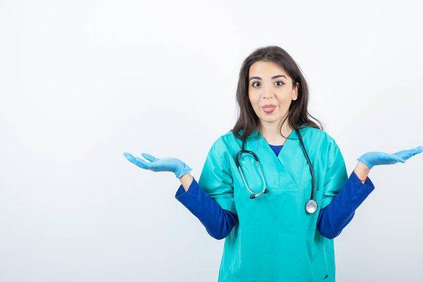 Retrato de jovem enfermeira com estetoscópio em pé em luvas médicas. Foto de alta qualidade - Foto, Imagem