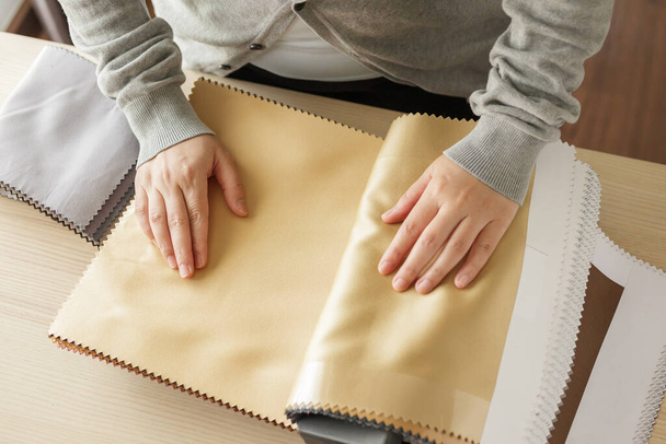 женщина-дизайнер с образцами цвета ткани, выбирающая текстиль для штор - Фото, изображение