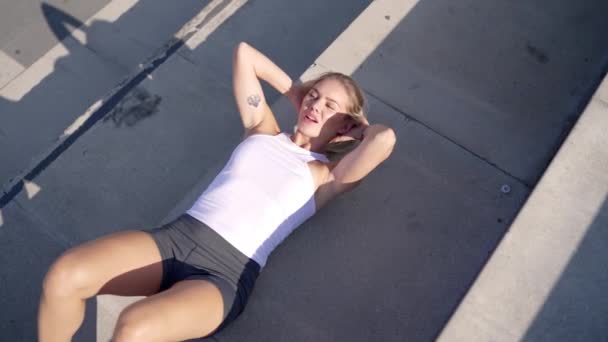 Sportovní žena dělá břišní cvičení na schodech - Záběry, video