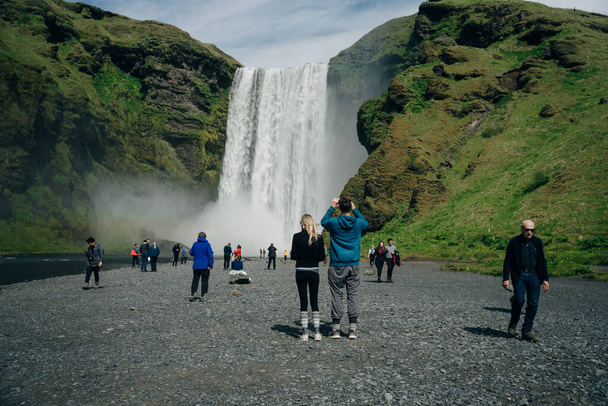 La cascade Skogarfoss dans le sud de l'Islande avec des touristes. Photo de haute qualité - Photo, image