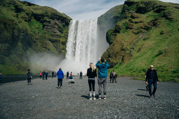 Водоспад Скогарфосс у південній Ісландії з туристами. Фотографія високої якості - Фото, зображення