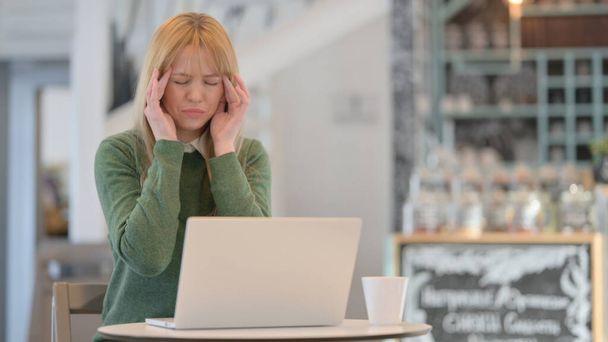 Nainen, jolla on päänsärkyä Työskentely Laptop Cafe  - Valokuva, kuva