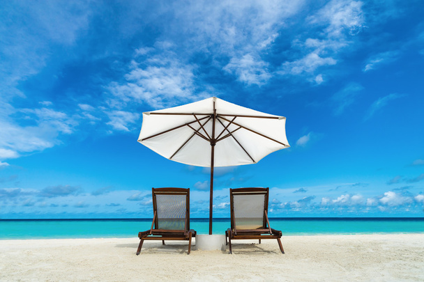 Ranta lounger ja sateenvarjo hiekkarannalla. Käsite levätä, rentoutumista, lomat, kylpylä, keinona
. - Valokuva, kuva