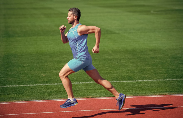 Athletic mature man running on stadium, speed - Foto, imagen
