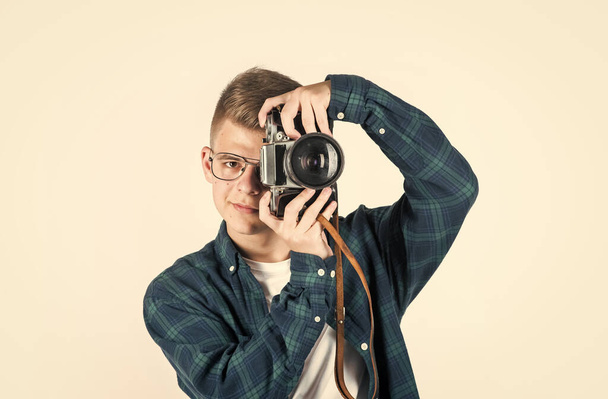 Genç çocuk eski fotoğraf makineli sıradan bir gömlek giyiyor. Beyaz tenli, fotoğrafçı. - Fotoğraf, Görsel