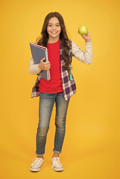 Eating well is good for your mental health. Happy child hold apple and books. Brain food. Natural diet. Dental health. Teeth hygiene. Health education. Healthy food in school thats really cool - Foto, Imagem