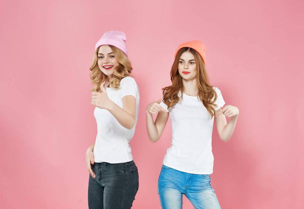 söpö tyttöystäviä halauksia muodikas vaatteita moderni tyyli vaaleanpunainen tausta - Valokuva, kuva