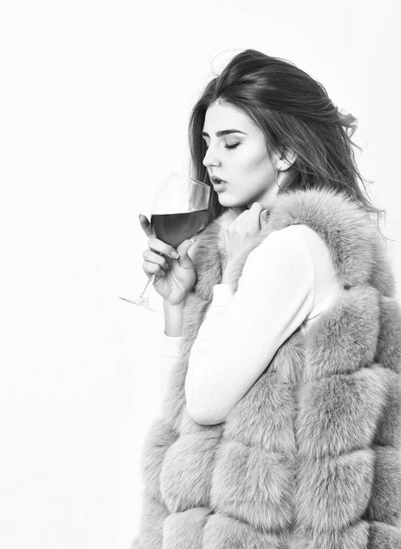 Alcohol and cold weather. Woman enjoy wine. Girl fashion makeup wear fur coat hold wine glass. Lady curly hairstyle like expensive wine. Luxury life concept. Reasons drink red wine in wintertime - Foto, Bild