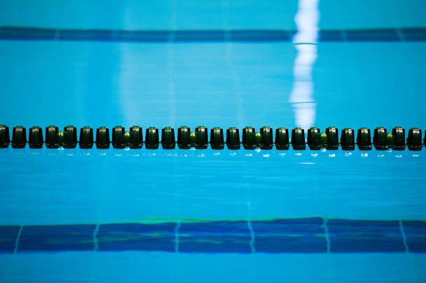 The view of an empty public swimming pool indoors. Lanes of a competition swimming pool - Photo, Image