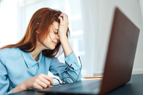 zmęczona kobieta siedzi przy stole przed laptopem praca niezadowolenie - Zdjęcie, obraz