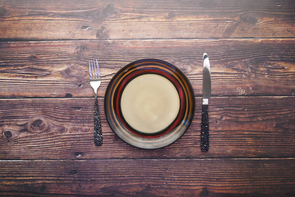 cutlery and empty plate on wooden background top down - Photo, Image