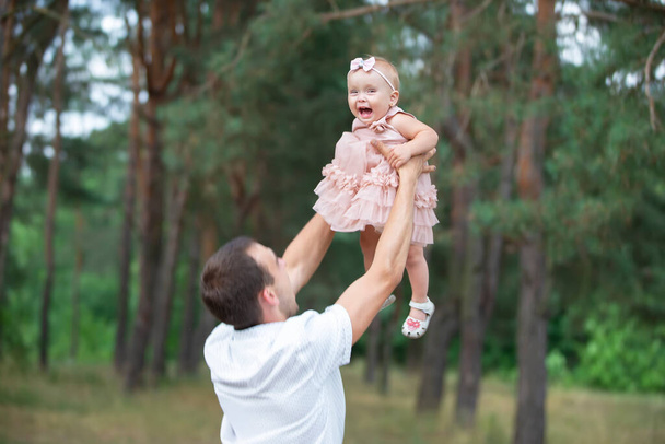 Szczęśliwy tata wymiotuje ze swoją córeczką na spacer. ojcostwo. - Zdjęcie, obraz