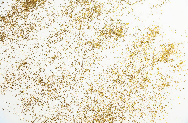 Sfondo festivo o glamour. Scintille d'oro sparse su uno sfondo bianco. - Foto, immagini