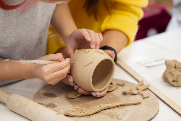子供の手は粘土コップを作る。粘土製品の作成のマスタークラス. - 写真・画像