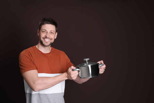 Happy man with pot on dark background. Space for text - Photo, Image