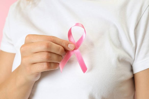 Junge Frau hält Brustkrebs-Bewusstseinsband aus nächster Nähe - Foto, Bild