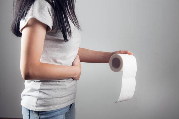 donna sta con carta igienica e mal di stomaco - Foto, immagini