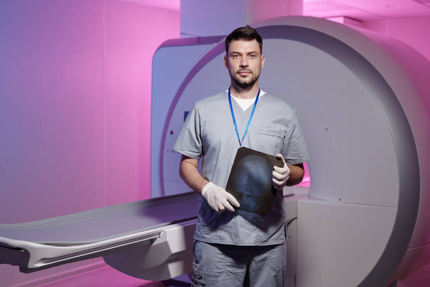Joven radiólogo exitoso con imagen de rayos X en el lugar de trabajo - Foto, Imagen