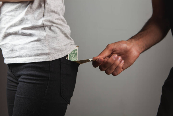 mężczyzna kradnie pieniądze z tylnej kieszeni kobiety - Zdjęcie, obraz