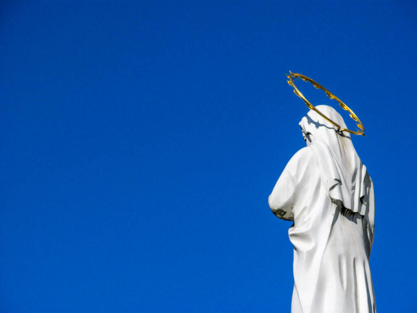 Pomnik Matki Bożej ze złotą aureolą nad nagimi - Zdjęcie, obraz