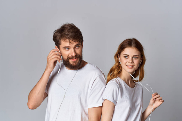 jeune couple écouter de la musique en t-shirts blancs amusant - Photo, image
