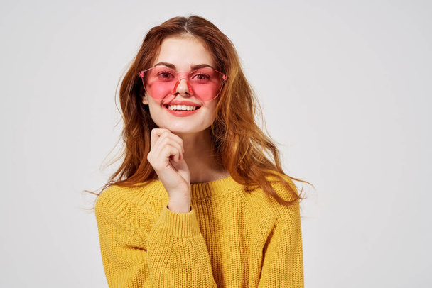 ritratto di una donna in occhiali alla moda acconciatura moda occhiali luce sfondo - Foto, immagini