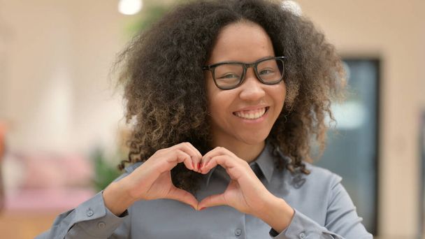 Portret van Afrikaanse zakenvrouw toont hart teken  - Foto, afbeelding