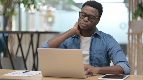 African Man mając ból szyi podczas pisania na laptopie  - Zdjęcie, obraz