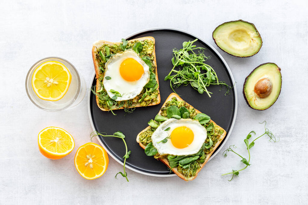 Toasts with eggs and avocado cream and spinach. Top view - Fotó, kép