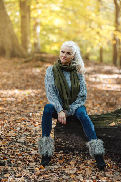 woman  in grey sweeter and jeans in Autumn park - Foto, afbeelding