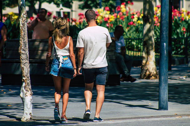 Σεβίλλη Ισπανία 28 Αυγούστου 2021 Πεζοί που περπατούν στους δρόμους της Σεβίλλης κατά τη διάρκεια της επιδημίας του κορωναϊού χτυπώντας την Ισπανία, φορώντας μάσκα δεν είναι υποχρεωτικό αλλά οι περισσότεροι το φορούν. - Φωτογραφία, εικόνα