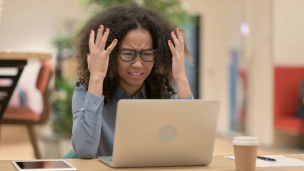 Afrikanerin mit Laptop reagiert auf Verlust  - Foto, Bild