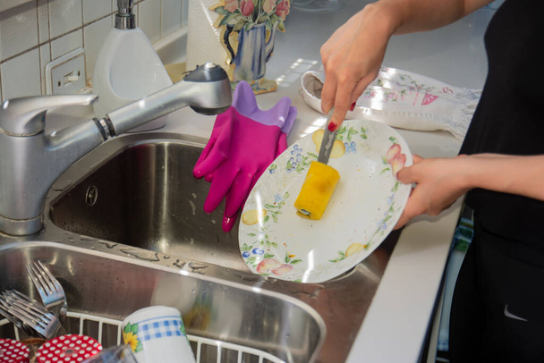 young woman washing dishes in the sink. - Photo, Image