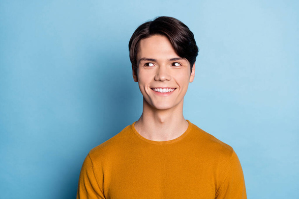 Photo of young handsome man happy positive smile curious look empty space isolated over blue color background - 写真・画像