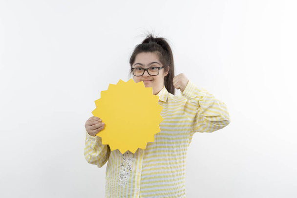 κορίτσι με σύνδρομο Down ποζάρουν με κίτρινο ήλιο μορφή κοπεί χαρτί - Φωτογραφία, εικόνα