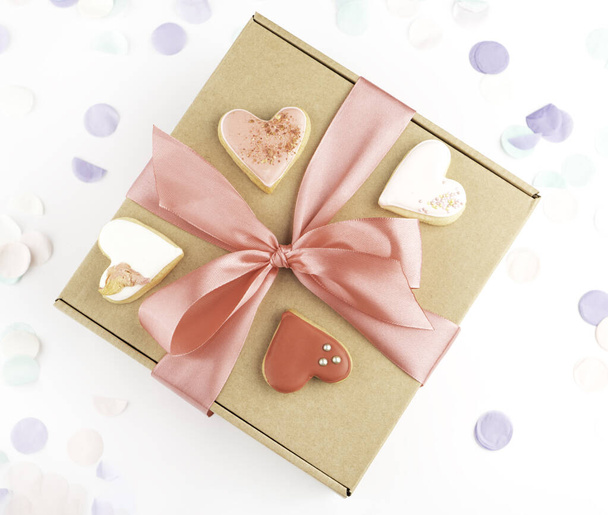 γιορτινή χειροτεχνία δώρο δώρο κουτί και καρδιά σχήμα πολύχρωμα μπισκότα για την ημέρα του Αγίου Βαλεντίνου, γιορτή της ημέρας της γυναίκας. Άνω όψη - Φωτογραφία, εικόνα