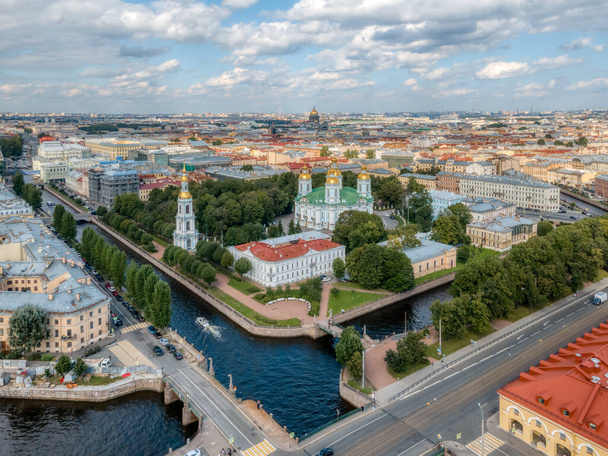 View from the top on St. Nicholas Cathedral with a bell tower in St Petersburg. Historical center. Russia in the summer. Tourism in russian cities. Cloudy scenic sky. Green public garden. - Photo, Image
