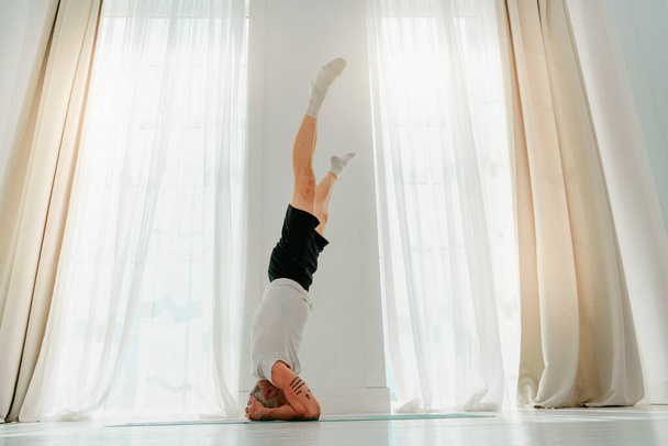 Sportive man does yoga exercise at home - Foto, Imagem
